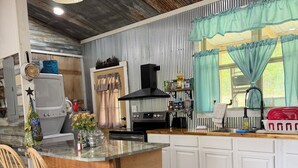 A kitchen with a wooden island, white cabinets, and a stainless steel range hood.
