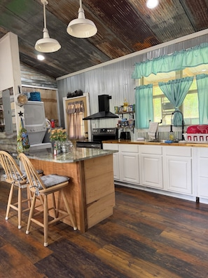 A kitchen with a wooden island, white cabinets, and a stainless steel range hood.