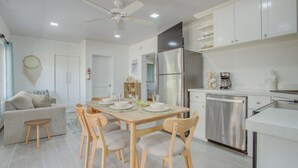 A modern kitchen with white cabinets, a stainless steel refrigerator, and a dishwasher.