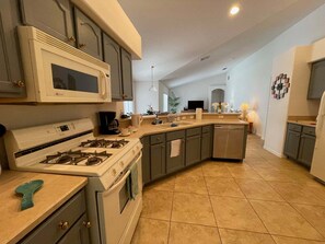 Una cocina equipada con estufa, microondas y lavabo.