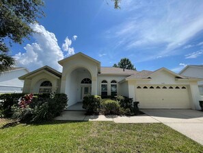 A two-story house with a garage, a front porch, and a well-maintained lawn. - 296 -Relaxing 4-Bedroom Villa with Private Pool, Spa & Games Room (Clermont)