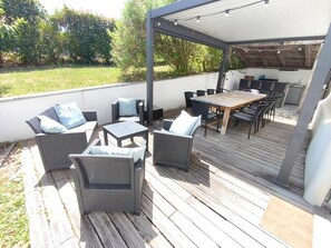 An outdoor patio with wicker furniture, a wooden table, and a covered seating area. - Saint Pée sur Nivelle, Ancienne labourdine parfaitement rénovée, 10 personnes, piscine (ST PEE SUR NIVELLE)