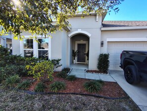 A house with a garage, a driveway, and a black SUV parked in front. - Family Friendly House Near Disney And Universal (Haines City)