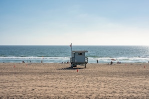 Una torre de salvavidas en una playa, con el océano al fondo.