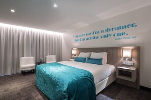 A hotel room with a large bed, two bedside tables, a headboard, and a quote on the wall. - Van Der Valk Vianen (Vianen)