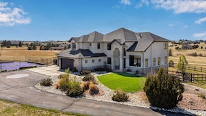 A two-story house with a garage, a driveway, and a well-maintained lawn.