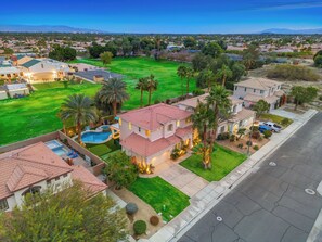 Zona residencial con casas, piscina y césped bien cuidado.