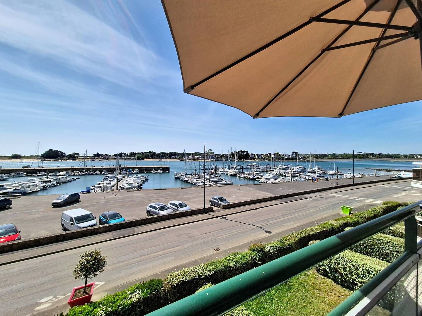 A marina with boats, a parking lot, and a clear sky.