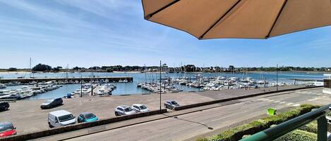 A marina with boats, a parking lot, and a clear sky.