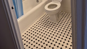 Een badkamer met een wit toilet, een bad en een douchegordijn.
