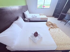 Une chambre d’hôtel avec deux lits, une grande fenêtre et une vue sur l’extérieur.