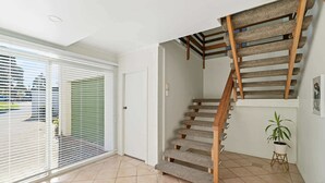 Una escalera de madera con barandilla, que conduce a un piso superior.