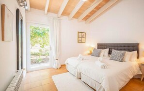 A bedroom with a large bed, a window with curtains, a radiator, and a framed picture on the wall. - Nice home in Campos with private swimming pool, can be inside or outside (Campos)