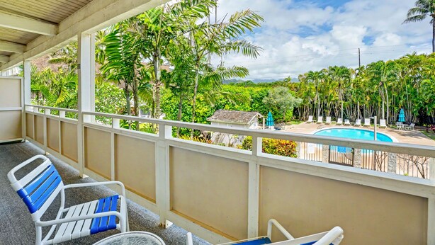 A covered balcony with a pool view, white railings, and lounge chairs. - Kauai Condo-Pool View 1BR with Private Lanai A/C (Kapaʻa)