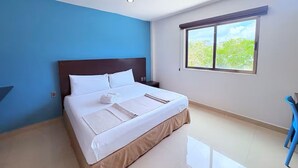 A bedroom with a bed, a window with a view, and a blue wall. - Beautiful King-Size Studio with Panoramic View (Playa del Carmen,)