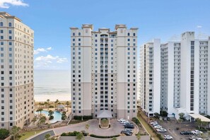 Ein Hochhotel mit einer zentralen Atrium, einem Pool und Blick auf den Strand.