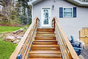 A wooden staircase leading to a house with a white door and blue shutters. - Remodeled Cottage with AC, Private W/D, Full Kitchen, and High-Speed WiFi (Boothbay Harbor)