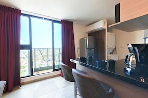 A modern kitchen with a bar area, large windows, and a view of the outdoors. - El Semillero (Monterrey)
