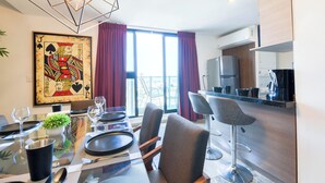 A modern dining area with a glass table, chairs, and a view of the city. - El Semillero (Monterrey)