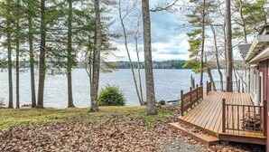 A lakeside property with a wooden deck, a dock, and a view of the lake. - Lakefront house on Damariscotta Lake, perfect getaway (Nobleboro)