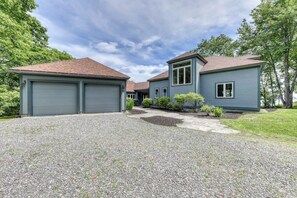 Ein zweistöckiges Haus mit Garage, überdachter Auffahrt und gepflegtem Rasen.