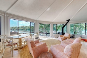 A spacious living room with a large window, a fireplace, and a dining area.