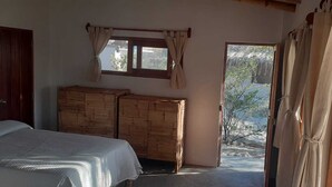 Une chambre à coucher avec un lit, une armoire en bois et une fenêtre avec des rideaux.