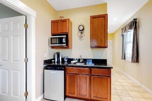 A kitchen with wooden cabinets, a microwave, a coffee maker, and a dishwasher.