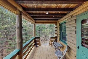 A wooden cabin with a porch, a table, and chairs. - Lakefront home w/ pristine views Outdoor firepit and full kitchen (Greenville)