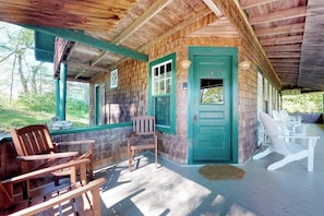 A wooden cabin with a porch, outdoor seating, and a door. - Historic Home with Large Deck, Free WiFi, Washer/Dryer - Near Beach and Downtown (Boothbay Harbor)