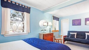 Une chambre à coucher comprenant un lit, une commode, une chaise et un canapé.