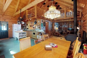 L’intérieur d’une cabane en rondins comprend un coin repas, une cuisine et un espace de vie.