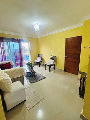 A living room with a white sofa, two armchairs, a coffee table, and a chandelier. - 2-bedrooms apartment in peaceful Concepción La Vega with AC (Concepción La Vega)