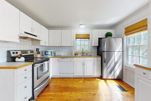 A kitchen with white cabinets, a stainless steel refrigerator, a microwave, and a stove. - Historic Home w/ Gas Fireplace, Fast WiFi, & Private W/D - Snowbird-Friendly (Warren)