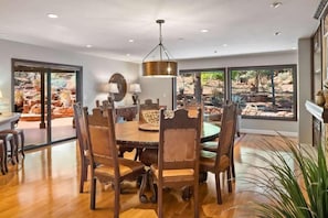 A dining area with a round table, six chairs, and a hanging light fixture. - 3 King Suites Walk to Uptown Views & Trails (Sedona)