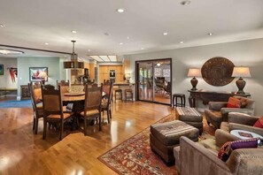 A spacious living room with a dining area, a kitchen in the background, and a large decorative wall piece. - 3 King Suites Walk to Uptown Views & Trails (Sedona)