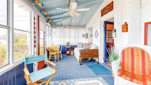 A cozy room with a bed, a chair, a desk, and a bookshelf. - Ocean Point Cottage- large porch, ocean view, water access (East Boothbay)