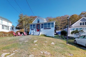 Ein Wohnhaus mit Veranda, Garage und einem Rasen mit Steinen.