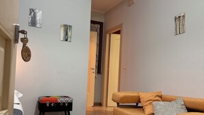 A living room with a sofa, a small table, and a rug.