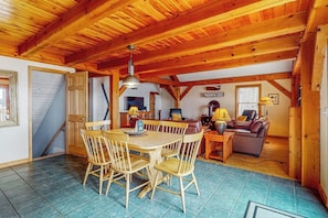 A wooden interior with a dining table and chairs, a sofa, and a sign reading 'Mosshead Lodge.' - Spectacular lakefront home with dock, firepit, & vaulted ceilings - dog-friendly (Greenville)