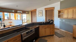 Una cucina moderna con mobili in legno, forno integrato e ventilatore a soffitto.