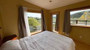Una camera da letto con un letto grande, due finestre e vista sul paesaggio.