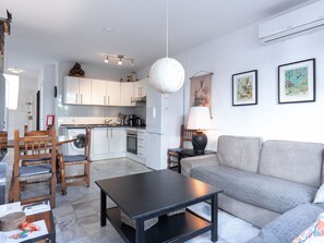 A modern living room with a sofa, a coffee table, and a dining area with chairs. - Apartment  by Interhome (Nerja)