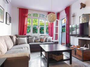 A modern living room with a sectional sofa, a coffee table, a TV, and a fireplace. - Apartment  by Interhome (Nerja)