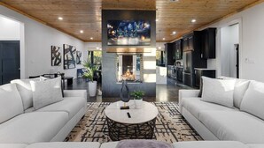 Uma sala de estar moderna com lareira, sofás e uma televisão.