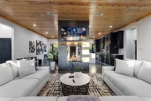 Ein modernes Wohnzimmer mit Kamin, Sofas und Fernseher.