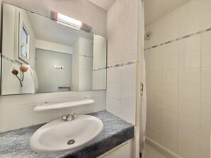 A bathroom with a white sink, a mirror, and a shower. - CAP D'AGDE - Plage Richelieu / Réf 0154 (CAP D'AGDE)