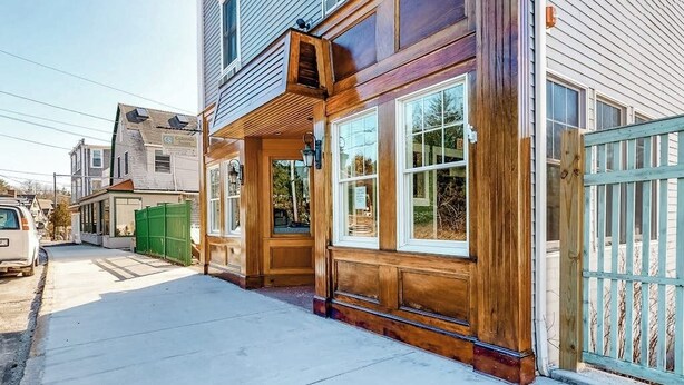 A two-story building with a wooden facade, large windows, and a gated entrance. - Lovely downtown Northeast Harbor suite near the water and near Acadia (Northeast Harbor)