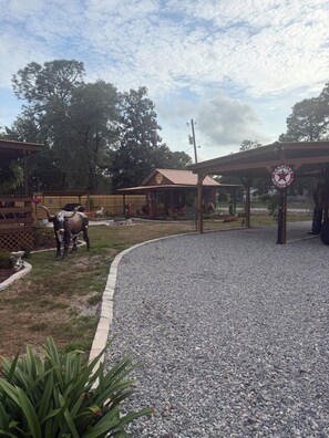 A rustic outdoor area with a gravel path, wooden structures, and a Texaco gas station sign. - Blue Sky Bungalow - 1-bedroom bungalow in Homosassa located just off 19! (Homosassa)