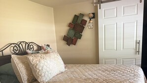 Ein Schlafzimmer mit einem Bett, einer Tür und einer Wandleuchte.